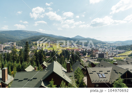 A review view of the resort city in the Carpathian mountains. Roofs of houses and mountains look very atmospheric A review view of the resort city in the Carpathian mountains. Roofs of houses and mountains look very atmospheric 104970692