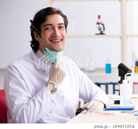 Young handsome chemist working in the lab Young handsome chemist working in the lab 104971058