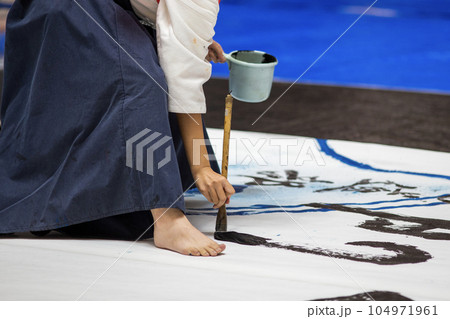 半紙の上に書を書いている女子高生 104971961
