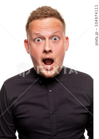Vertical shot of stupefied stunned shocked young male keeps mouth widely opened, being surprised and very emotional, expresses great surprisment. 104974111