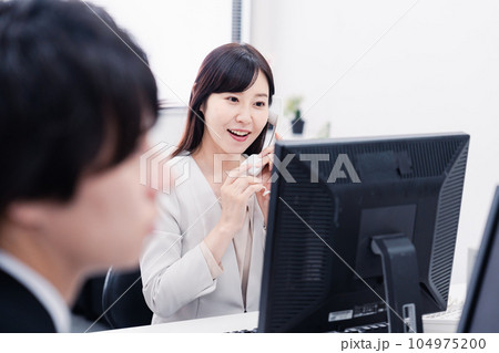 オフィスで電話対応をする女性社員 オフィスで電話対応をする女性社員 104975200