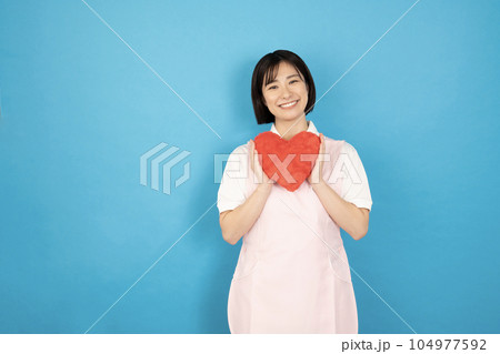 赤いハートを持って微笑む介護士の女性 104977592