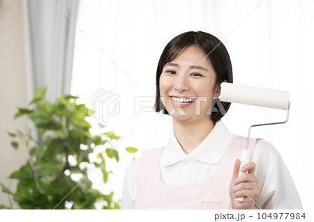 笑顔でカーペットクリーナーを持つ女性 104977984