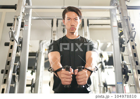 ケーブルマシンで体を鍛える男性 104978810