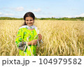 Cute pakistani girl in national dress stends in the field of golden wheat and smiling 104979582