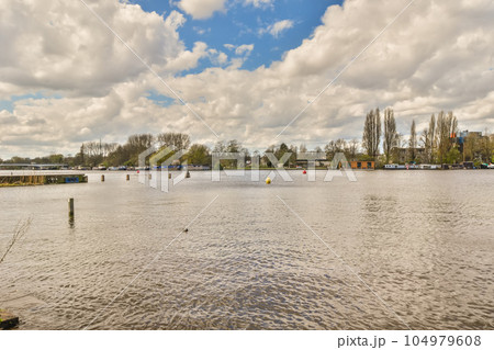 some water and trees in the middle of a large body of water with boats floating on it's surface 104979608