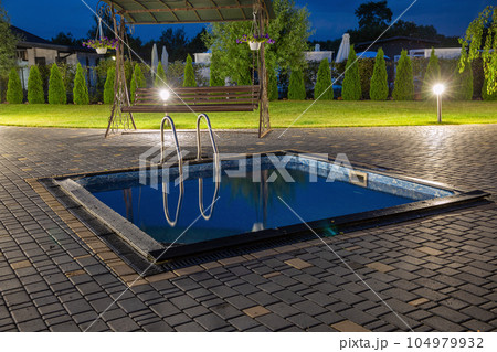 Small outdoor swimming pool in the evening. 104979932
