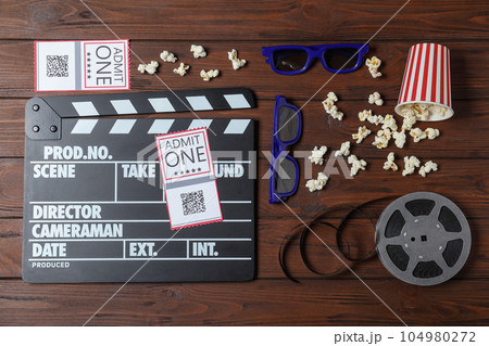Flat lay composition with clapperboard, cinema tickets and 3d glasses on wooden table Flat lay composition with clapperboard, cinema tickets and 3d glasses on wooden table 104980272