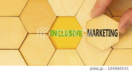 Inclusive marketing symbol. Concept words Inclusive marketing on beautiful wooden puzzles. Beautiful yellow background. Businessman hand. Business inclusive marketing concept. Copy space. Inclusive marketing symbol. Concept words Inclusive marketing on beautiful wooden puzzles. Beautiful yellow background. Businessman hand. Business inclusive marketing concept. Copy space. 104980541