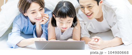 ベットで動画を観る親子 ベットで動画を観る親子 104980668
