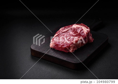 Fresh, raw beef steak with salt, spices and herbs Fresh, raw beef steak with salt, spices and herbs 104980799
