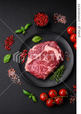 Fresh, raw beef steak with salt, spices and herbs Fresh, raw beef steak with salt, spices and herbs 104980830