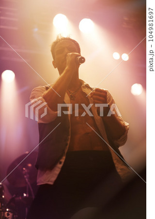 Concert, music and singer with man on stage for night, festival and rock performance. Spotlight, karaoke and band with male artist singing in show for musician, clubbing and disco party event Concert, music and singer with man on stage for night, festival and rock performance. Spotlight, karaoke and band with male artist singing in show for musician, clubbing and disco party event 104981697