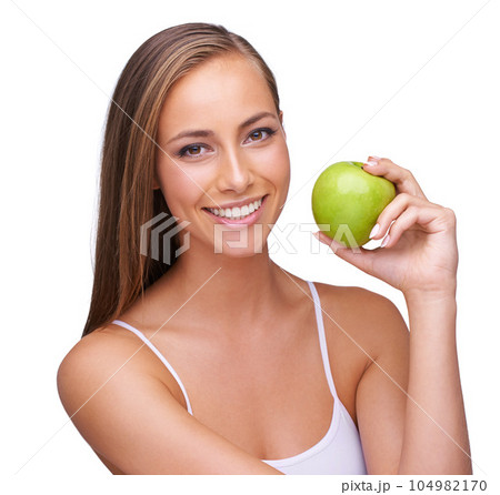 Apple, wellness and portrait of woman on a white background for healthy lifestyle, cosmetics and wellbeing. Diet, healthcare and face of girl with fruit for organic products, vitamins and nutrition 104982170