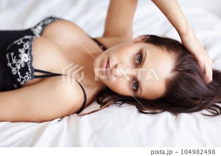 Beauty, sexy and lingerie with portrait of woman in bedroom for sensual, body confidence and elegant fashion. Relax, temptation and desire with girl in underwear on bed for makeup, flirting and home 104982498