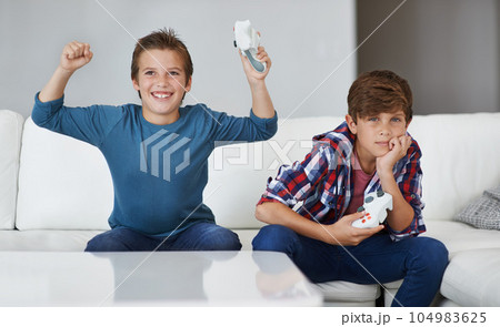 Boys playing video game, celebrate and friends gaming with tech, esports and entertainment with winner. Gamer kids play games on console at home, happy with win and male children have fun together 104983625