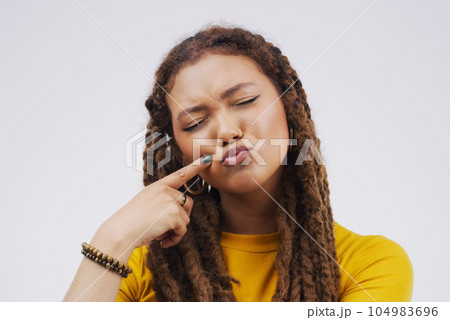 Finger, funny face and pout with a black woman joking in studio on a white background for humor. Comic, comedy and duckface with a pouting young female person feeling playful while having fun 104983696