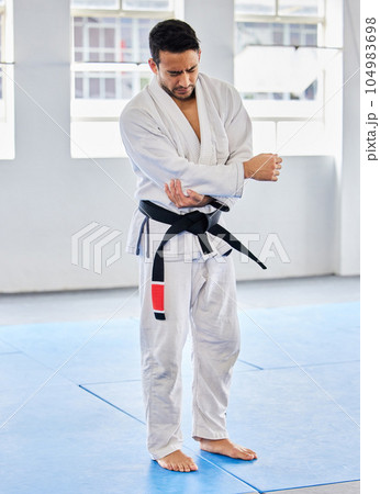 Karate injury, hurt and elbow pain for a man athlete holding painful arm at the gym. Active, Sport and athletic male suffering from muscle inflammation due to an exercise, fight training or workout Karate injury, hurt and elbow pain for a man athlete holding painful arm at the gym. Active, Sport and athletic male suffering from muscle inflammation due to an exercise, fight training or workout 104983698