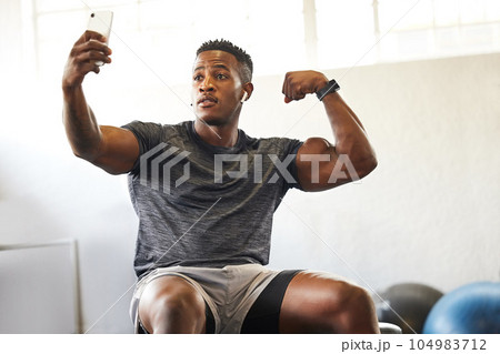 Selfie, muscle flex and man for gym, fitness and workout results, progress and social media update of body goals. Bodybuilder or african person with profile picture, photography and exercise in power 104983712