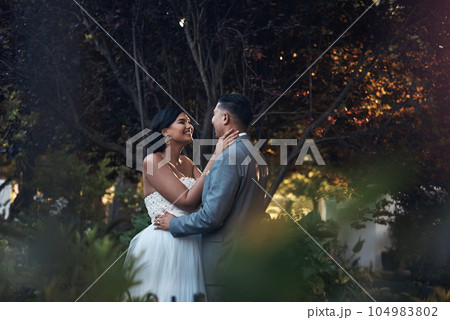 Nature, outdoor and couple with love, wedding and bonding with happiness, relationship and embrace. Partners, bride and groom outdoor, park and hug with marriage, loving and romance with celebration 104983802
