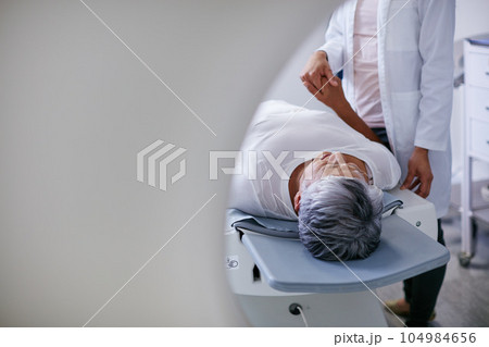 Doctor, mri and woman holding hands of patient in hospital before scanning in machine. Ct scan, cancer and medical professional with senior person in radiology test for healthcare in clinic. Doctor, mri and woman holding hands of patient in hospital before scanning in machine. Ct scan, cancer and medical professional with senior person in radiology test for healthcare in clinic. 104984656