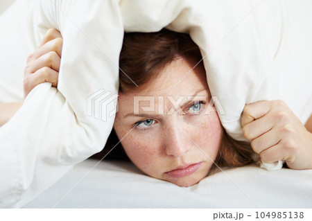 Insomnia, noise and woman with pillow on ears to block loud sound, sleep fail and tired on bed in bedroom. Stress, person and covering head with cushion for problem, tinnitus and frustrated at night. Insomnia, noise and woman with pillow on ears to block loud sound, sleep fail and tired on bed in bedroom. Stress, person and covering head with cushion for problem, tinnitus and frustrated at night. 104985138