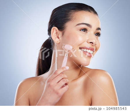 Derma roller, skincare and asian woman in studio for anti aging, cosmetic or face massage on grey background. Rose quartz, facial and lady wellness model with luxury, beauty or lymphatic drainage 104985543