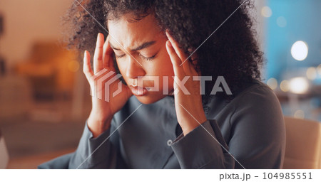 Burnout, night and woman with a headache in the office while working on a deadline corporate project. Stress, migraine and tired professional female business employee with frustration in workplace. 104985551