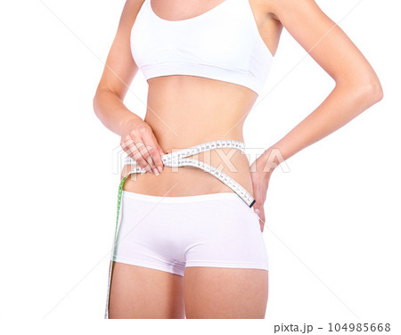 Woman, waist and measuring tape in studio with hands, weight loss or fitness for wellness by white background. Isolated model, girl and underwear with diet goal, body or stomach for healthy abdomen 104985668