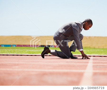 Start, race track and man in a suit for sport, running and fitness, cardio and speed practice. Starting line, ready and formal male sports runner at a stadium for challenge, performance and workout 104985719