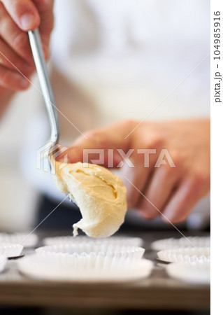 Closeup, hands and cupcake dough in tray with baker, small business owner and professional chef. Cooking, bakery and cake in baking pan for food, job and start process for muffins in shop kitchen Closeup, hands and cupcake dough in tray with baker, small business owner and professional chef. Cooking, bakery and cake in baking pan for food, job and start process for muffins in shop kitchen 104985916