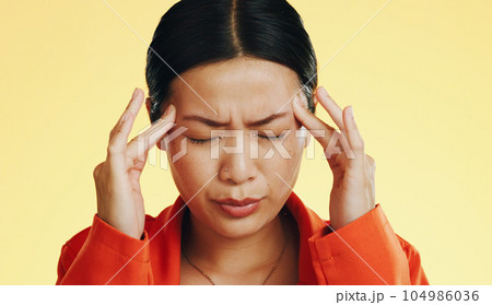 Asian woman, headache and studio with stress, migraine and hands on head to massage temple by background. Young japanese model, pain and anxiety with mental health, fatigue and burnout by backdrop Asian woman, headache and studio with stress, migraine and hands on head to massage temple by background. Young japanese model, pain and anxiety with mental health, fatigue and burnout by backdrop 104986036