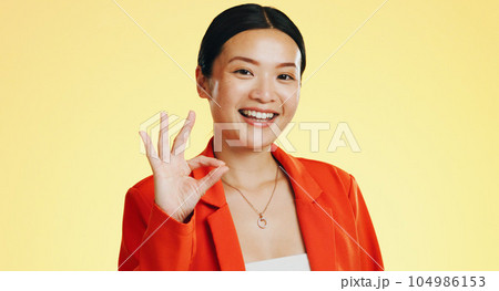Smile, ok sign and face of Asian woman on yellow background for perfect, good job and agreement. Emoji mockup, hand gesture and portrait of happy girl in studio with success, okay symbol and yes icon 104986153