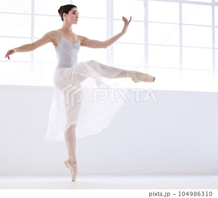 Dance, ballet and moving with woman in studio for balance, elegant and performance. Artist, theatre and training with female ballerina dancing in class for competition, freedom and commitment 104986310
