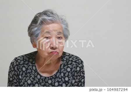 口をとがらせてムッとする高齢女性 104987294