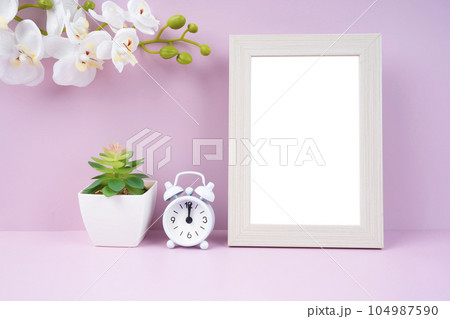 The Blank picture frame and alarm clock on pink color background with copy space and clipping path for the inside. The Blank picture frame and alarm clock on pink color background with copy space and clipping path for the inside. 104987590