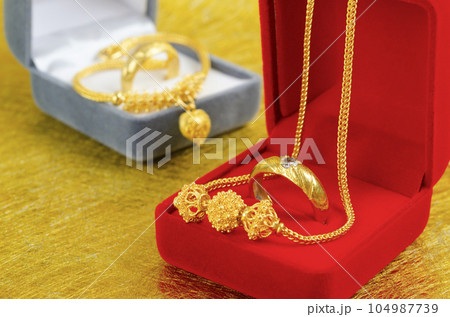 The Gold necklace and heart shape pendant with ring on red velvet box. 104987739