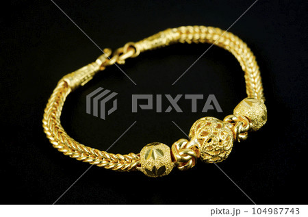 The Gold bracelet on black background. The Gold bracelet on black background. 104987743
