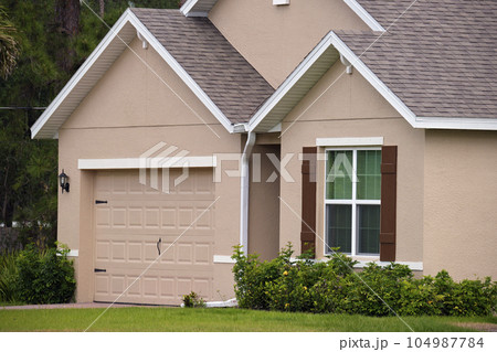 Wide garage double door and concrete driveway of new modern american house Wide garage double door and concrete driveway of new modern american house 104987784