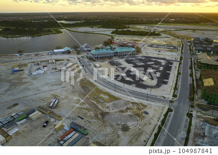 View from above of unfinished frame of apartment condos with wooden roof beams under construction. Development of residential housing in US suburbs. Real estate market in the USA 104987841
