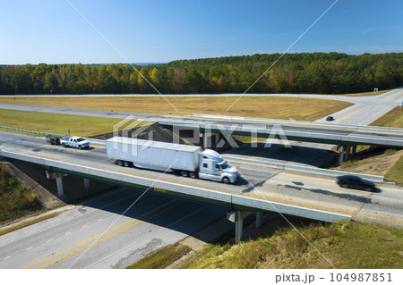 View from above of busy american highway with fast moving traffic between woods. Interstate transportation concept 104987851
