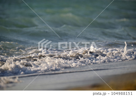 Seaside sand beach with foamy waves crushing on shore Seaside sand beach with foamy waves crushing on shore 104988151