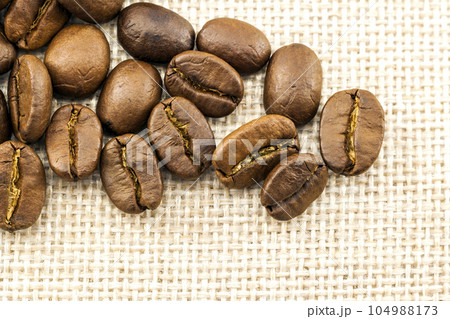 Roasted coffee beans on burlap sackcloth texture background Roasted coffee beans on burlap sackcloth texture background 104988173