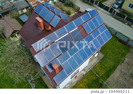 Private home roof covered with solar photovoltaic panels for generating of clean ecological electric energy in suburban rural town area. Concept of autonomous house 104988211