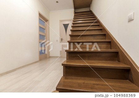 Modern architecture interior with elegant luxury hallway with glossy wooden staps stairs in modern storey house 104988369