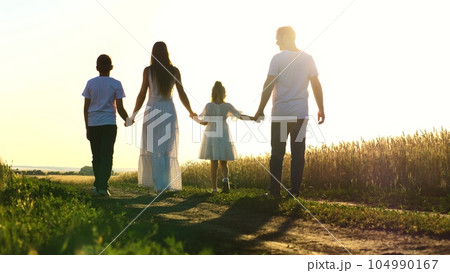 mother father child daughter son walk sunset, holding hands parents girl boy. happy family, wheat field, childhood dream, green garden, love for children, happy family and little child holding hands 104990167