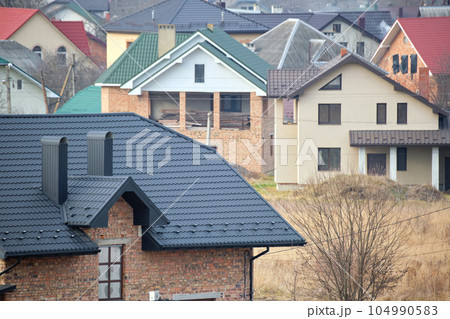 Chimney on house roof top covered with metallic shingles under construction. Tiled covering of building. Real estate development Chimney on house roof top covered with metallic shingles under construction. Tiled covering of building. Real estate development 104990583