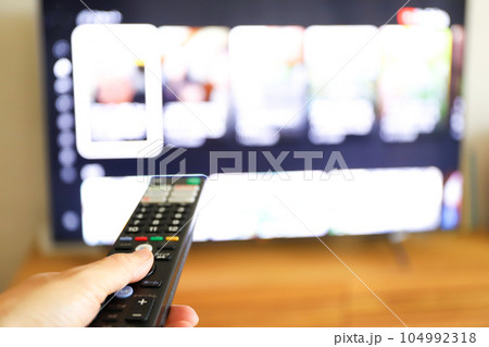 リモコンでテレビを操作する手元 リモコンでテレビを操作する手元 104992318