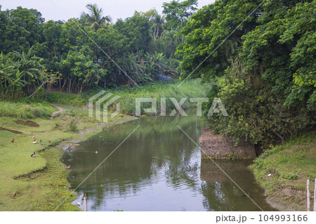 River water flows through the cannel with a greenery landscape view under the blue sky River water flows through the cannel with a greenery landscape view under the blue sky 104993166