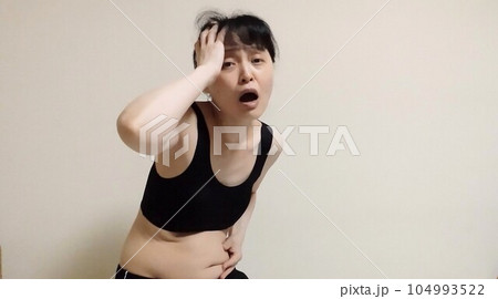 三段腹に絶望する女性の写真素材 [104993522] - PIXTA